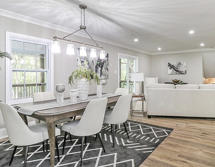 Light-tone plank flooring through a dining and living area completed by Dbest Flooring LLC