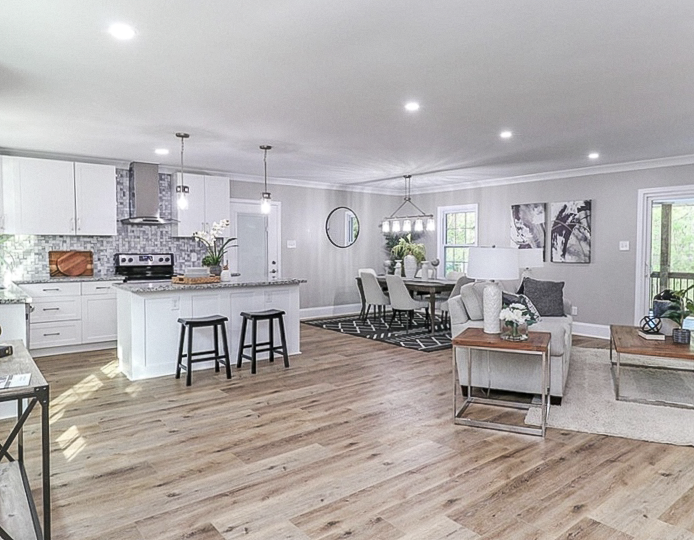 Light-tone plank flooring in an open-concept home completed by Dbest Flooring LLC
